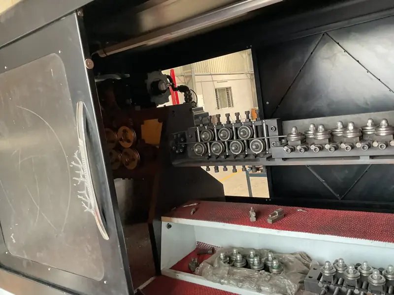 Inside a wire forming machine: rows of straightening rollers and bolts